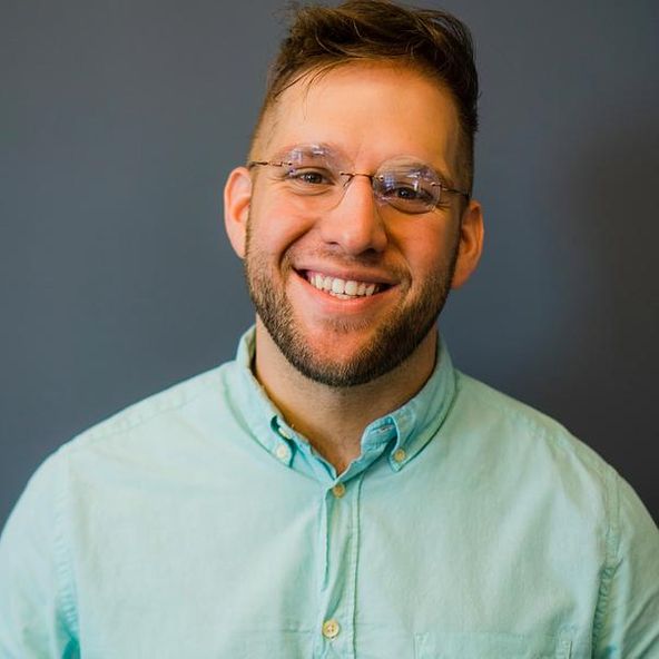 Brett Fink smiling in glasses and a light green shirt